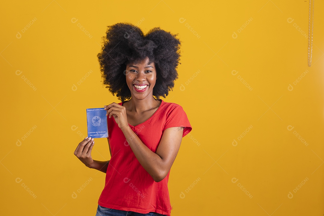 Mulher negra sorridente usando uma camiseta vermelha e segurando uma carteira de trabalho