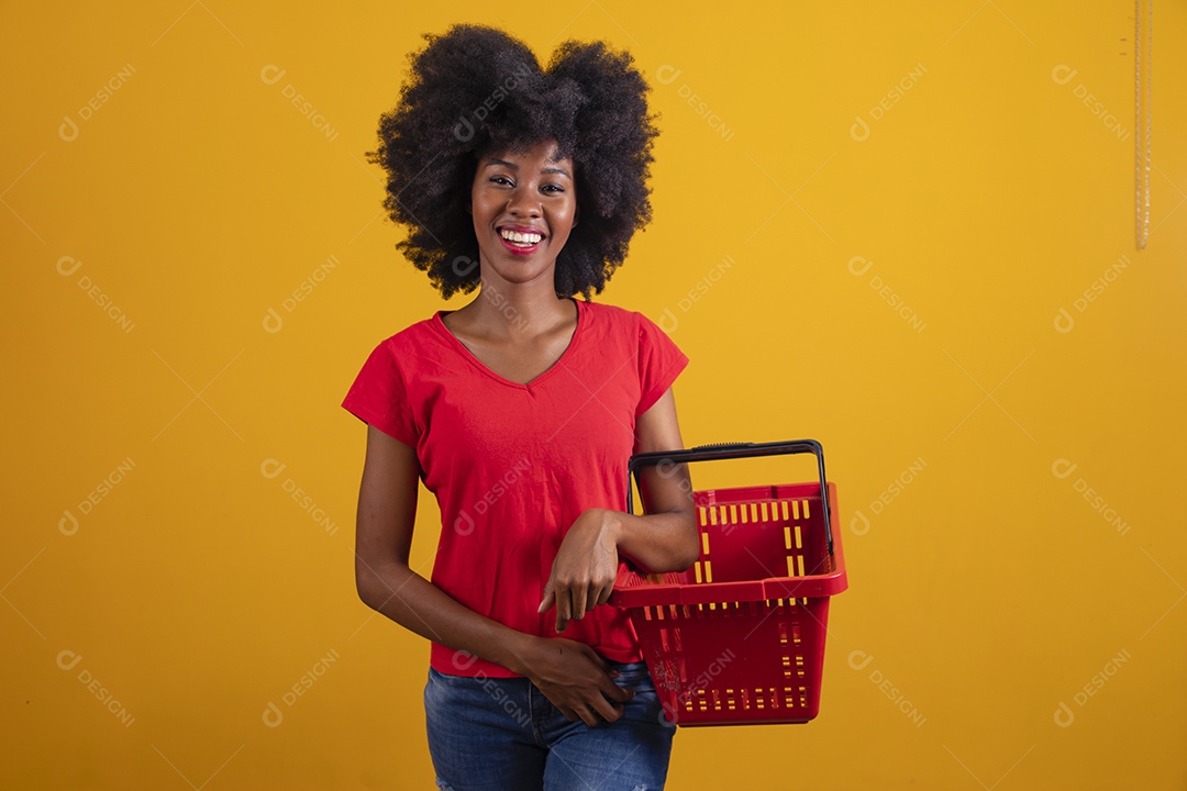 Mulher negra sorridente usando uma camiseta vermelha e segurando uma cesta de compras