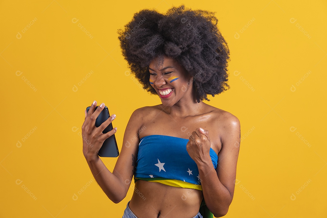 Mulher negra vestindo bandeira do Brasil segurando um smartphone celular