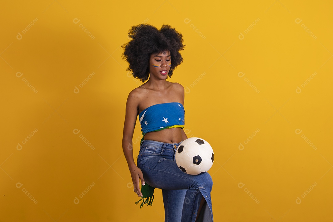 Mulher negra vestindo bandeira do Brasil e jogando bola