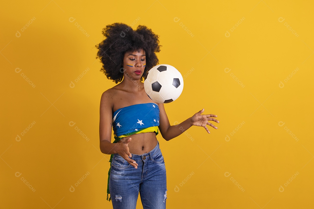 Mulher negra vestindo bandeira do Brasil e jogando bola