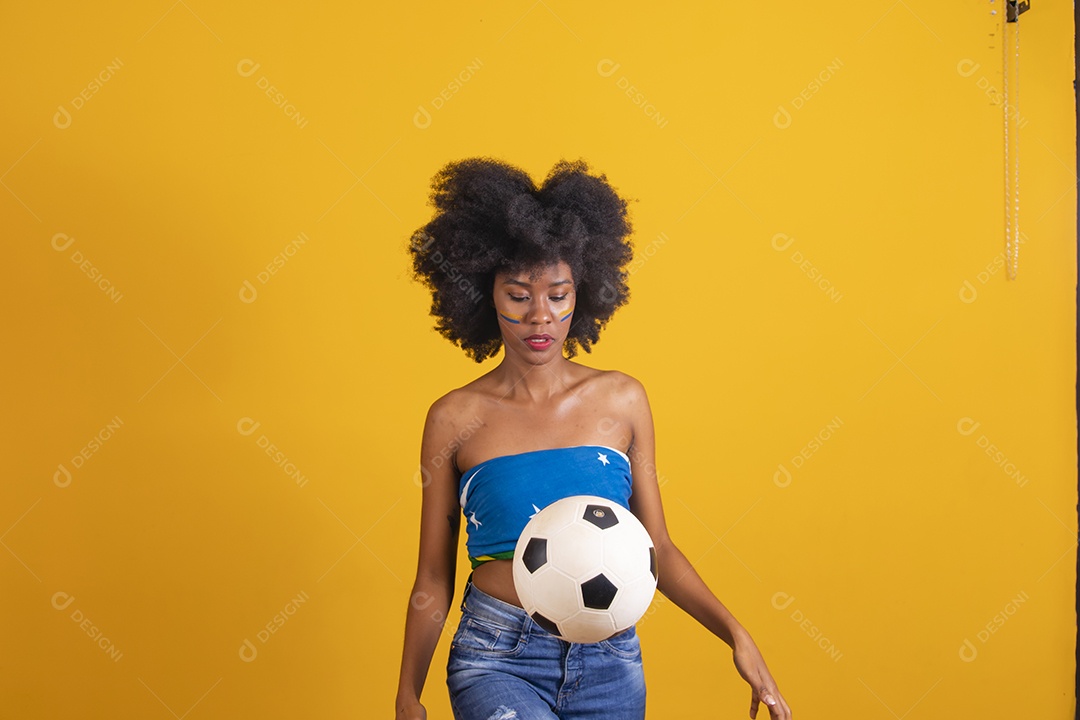 Mulher negra vestindo bandeira do Brasil e jogando bola