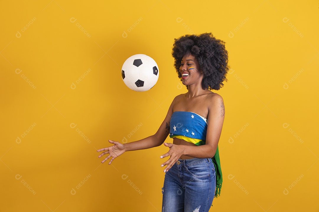 Mulher negra vestindo bandeira do Brasil e jogando bola