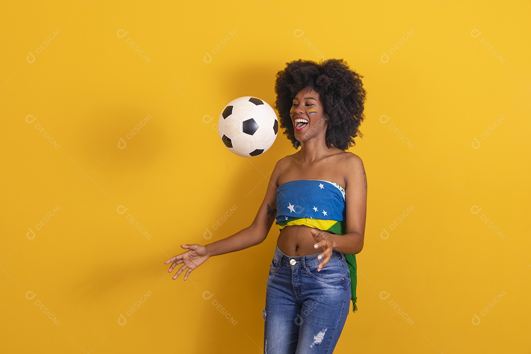 Mulher negra vestindo bandeira do Brasil e jogando bola