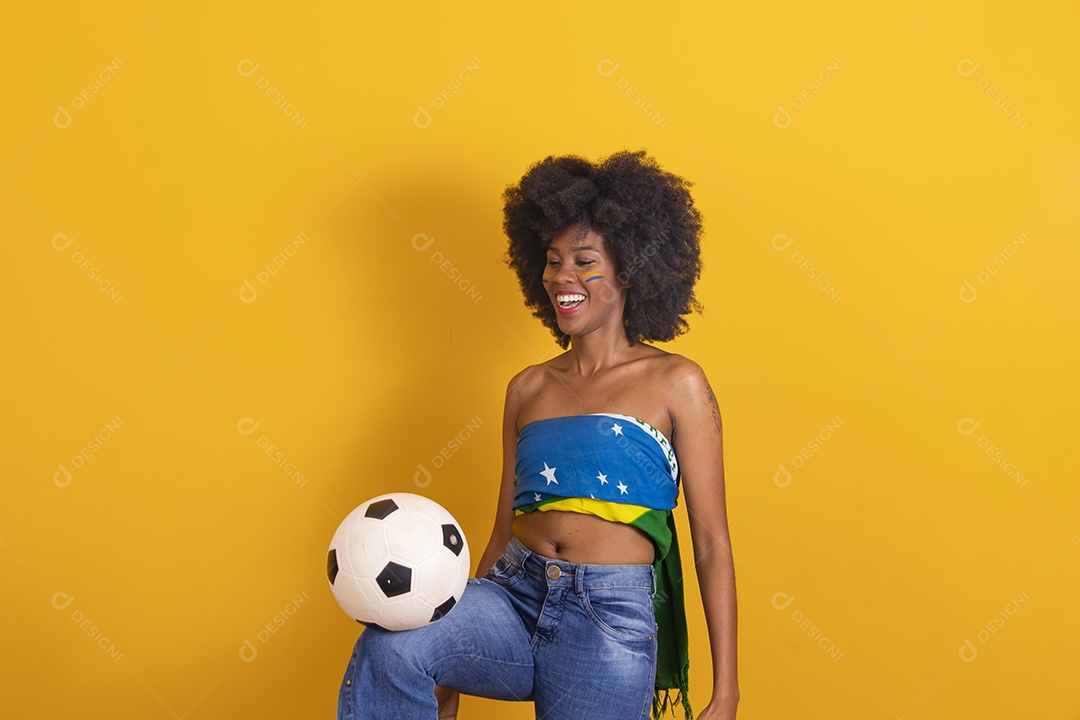 Mulher negra vestindo bandeira do Brasil e jogando bola