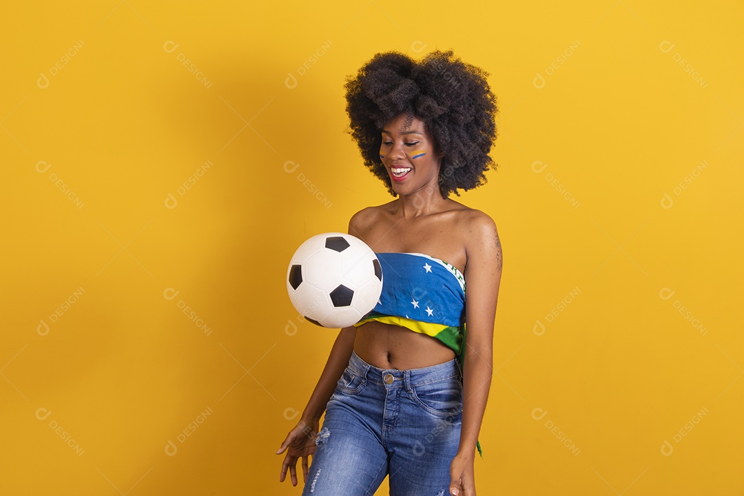 Mulher negra vestindo bandeira do Brasil e jogando bola