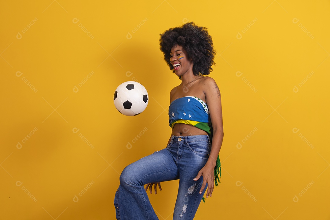 Mulher negra vestindo bandeira do Brasil e jogando bola