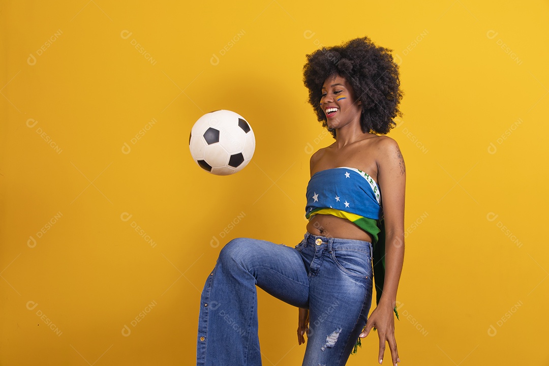 Mulher negra vestindo bandeira do Brasil e jogando bola