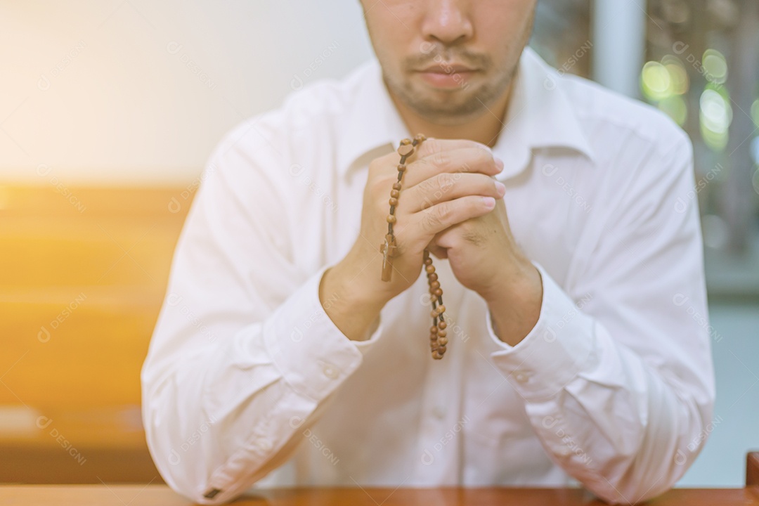 Homem fazendo oração sobre uma igreja católica