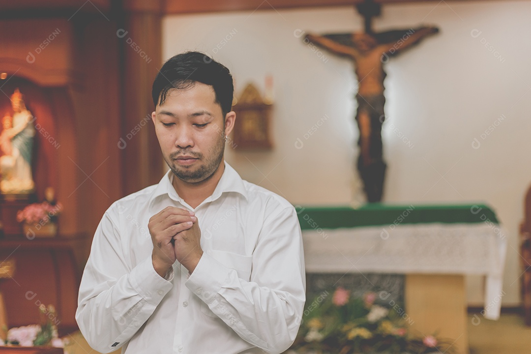 Homem fazendo oração sobre uma igreja católica