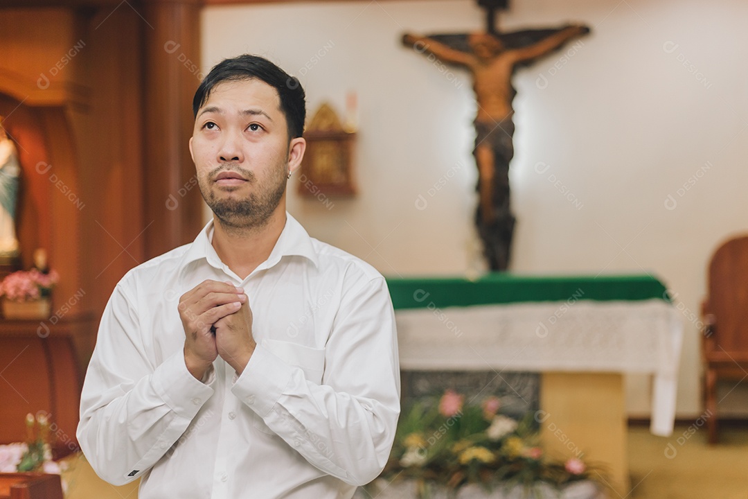 Homem fazendo oração sobre uma igreja católica