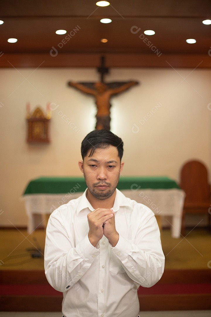 Homem fazendo oração sobre uma igreja católica