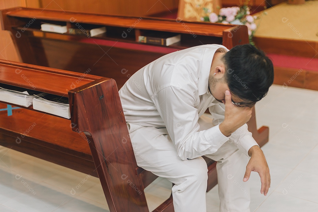 Homem fazendo oração sobre uma igreja católica