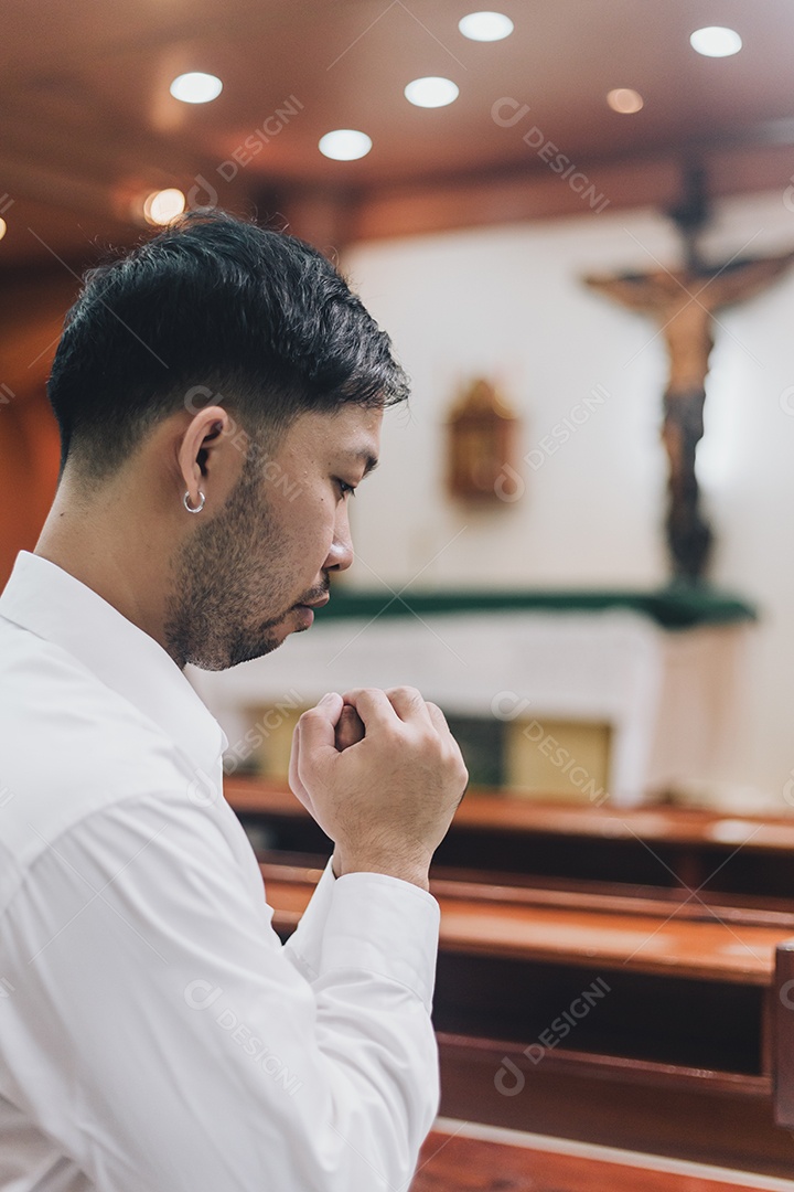 Homem fazendo oração sobre uma igreja católica