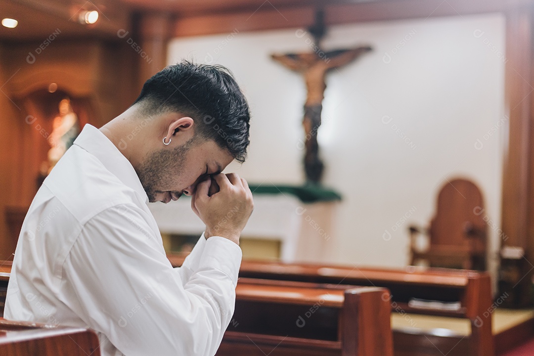 Homem fazendo oração sobre uma igreja católica