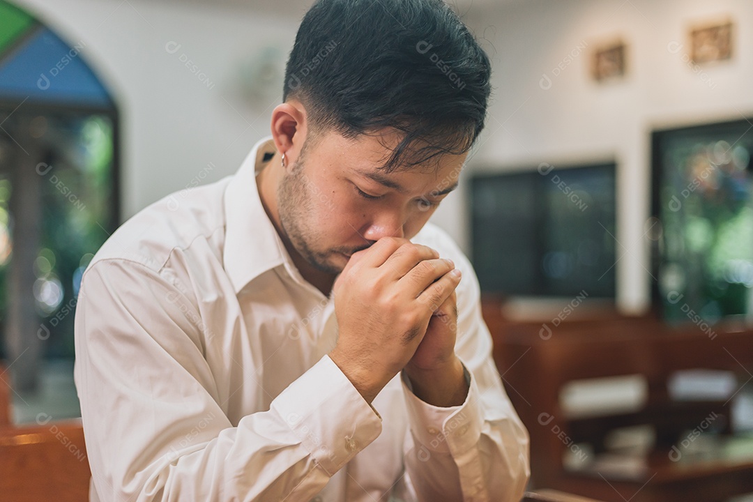 Homem fazendo oração sobre uma igreja católica