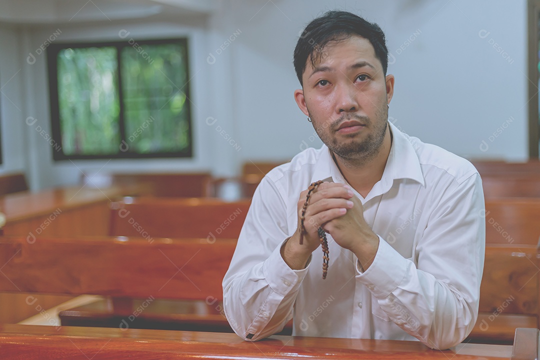 Homem fazendo oração sobre uma igreja católica