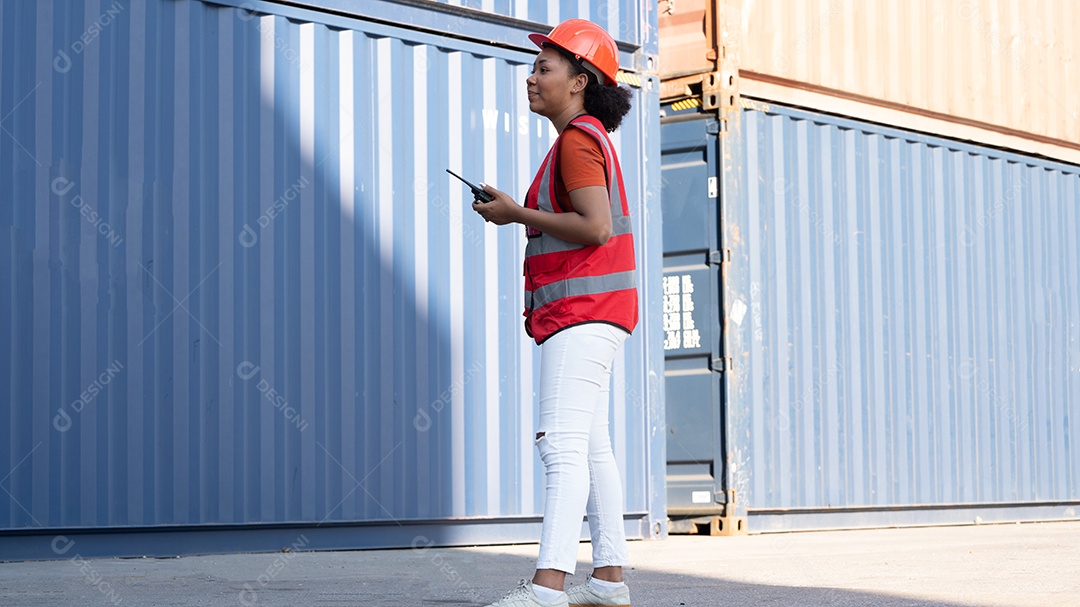 Capataz de mulher segurando o controle de walkie talkie carregando os recipientes