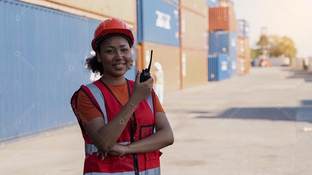 Capataz de mulher segurando o controle de walkie talkie carregando os recipientes