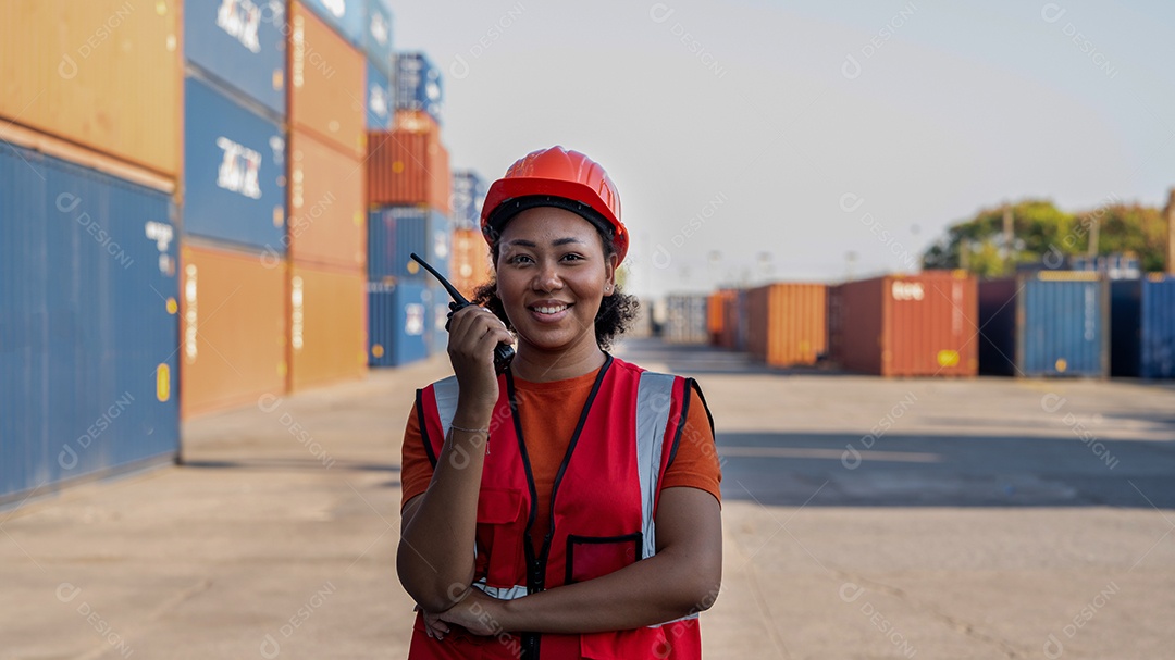 Capataz de mulher segurando o controle de walkie talkie carregando os recipientes