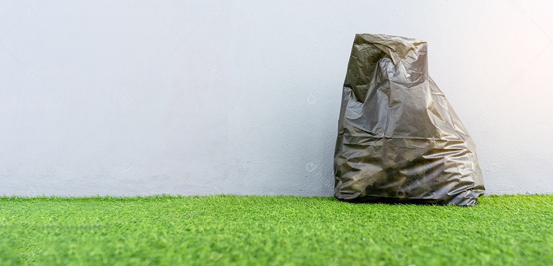 Saco de lixo em fundo cinza e campo verde