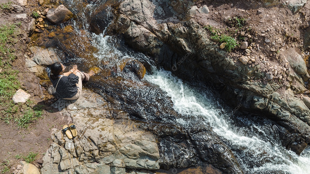 Vista aérea da mulher relaxando com belas águas naturais