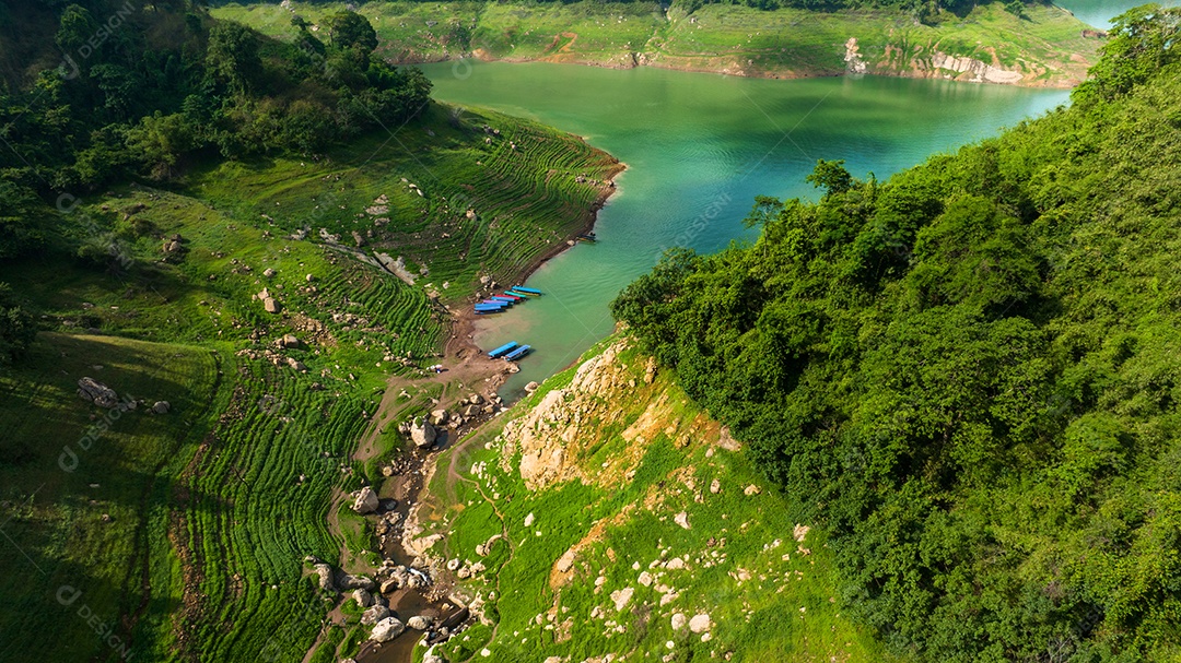 Vista aérea do belo córrego de água natural e campo verde o