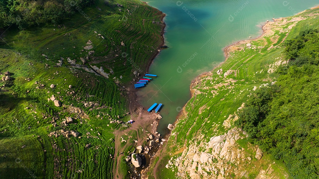 Vista aérea do belo córrego de água natural e campo verde