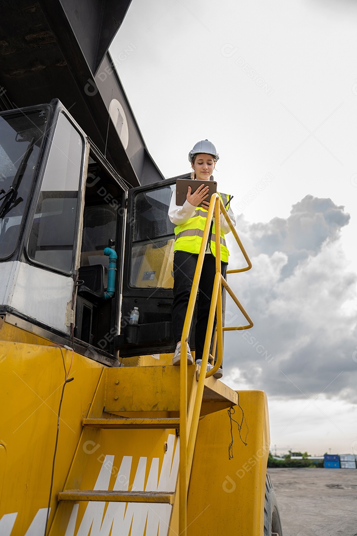O capataz feminino fica na verificação de empilhadeira de carga de contêiner de empilhadeira ou inspeciona e controla o serviço