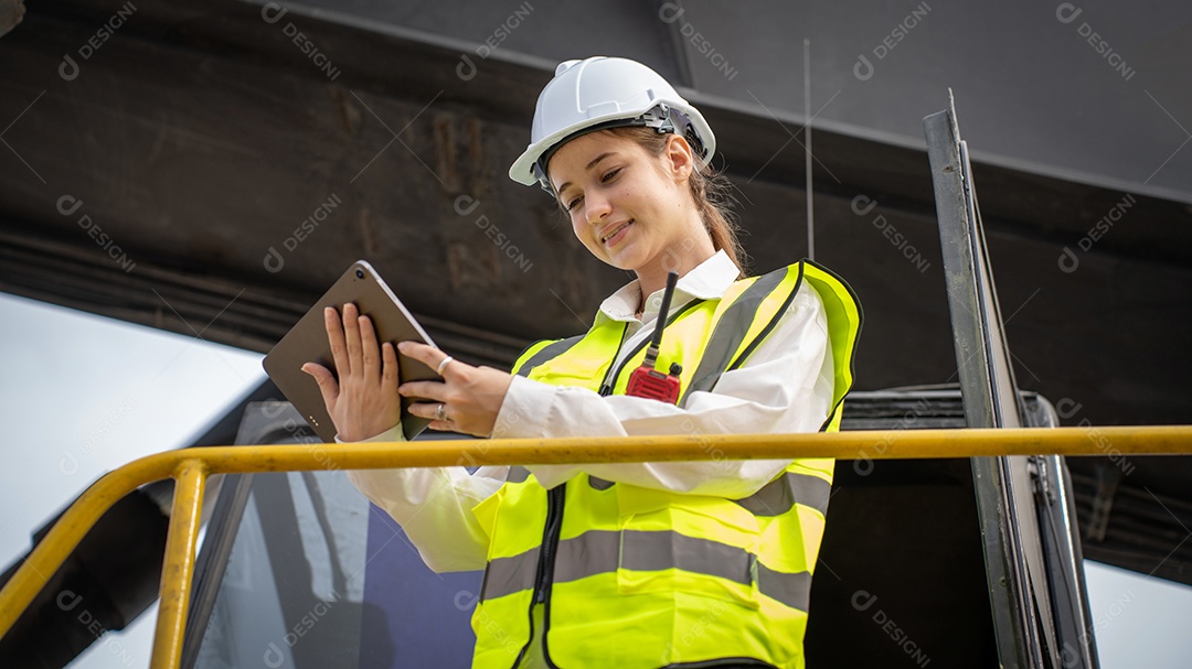 O capataz feminino fica na verificação de empilhadeira de carga de contêiner de empilhadeira ou inspeciona e controla o serviço