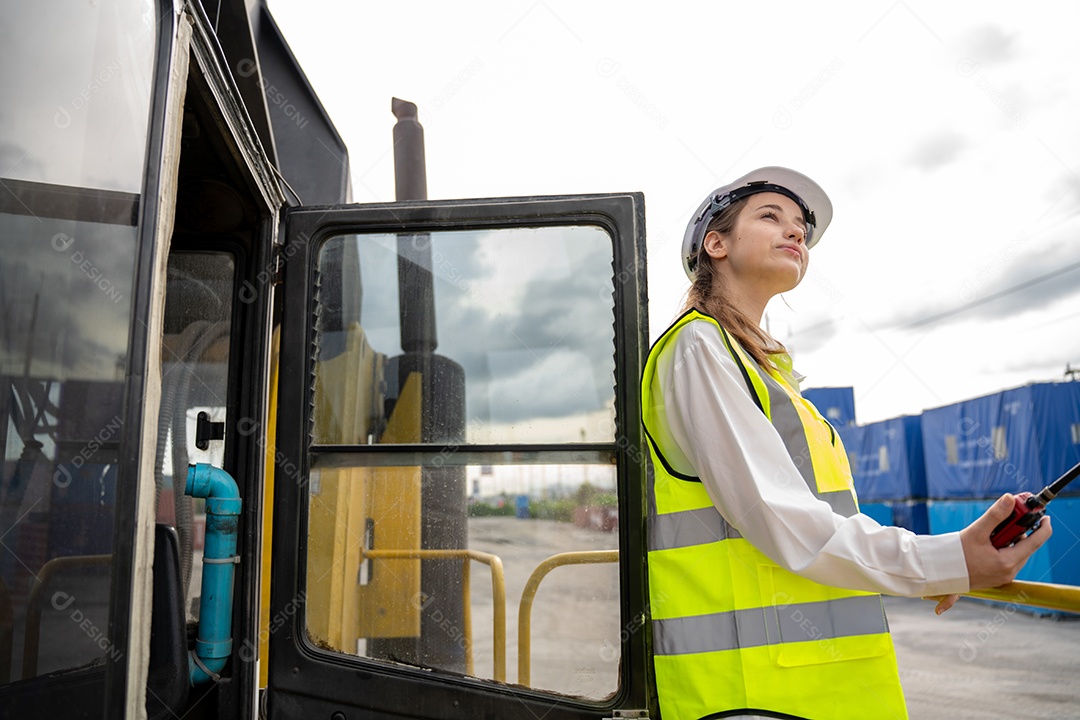 Foreman feminino fica na empilhadeira de carga de contêiner de empilhadeira