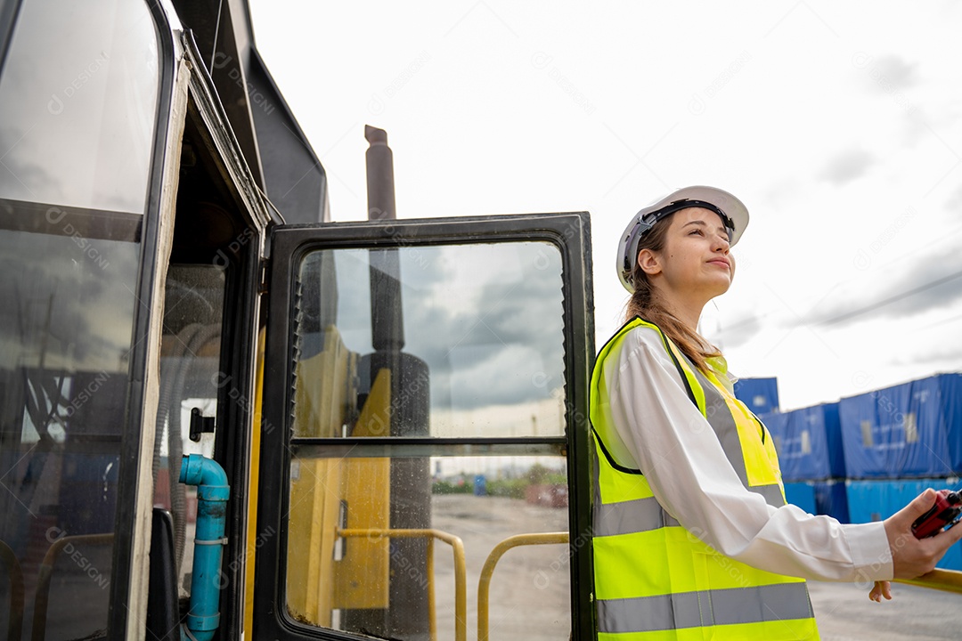 Foreman feminino fica na empilhadeira de carga de contêiner de empilhadeira