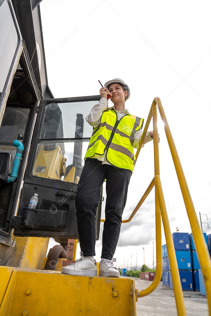 Foreman feminino fica na empilhadeira de carga de contêiner de empilhadeira