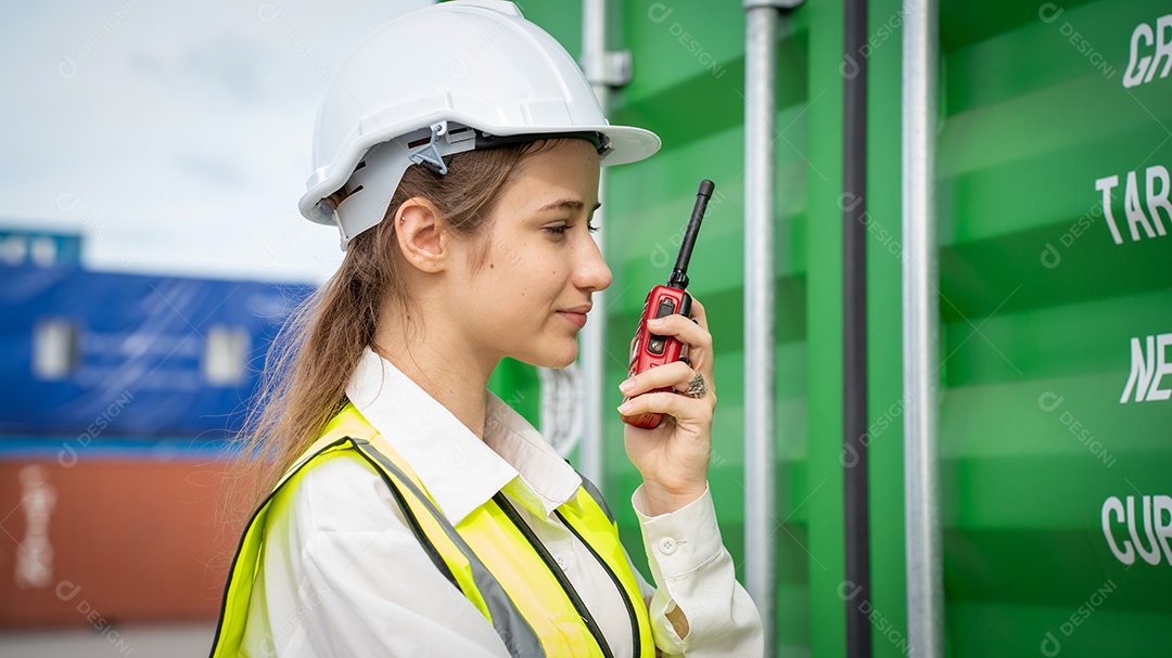 Mulher capataz sorri ao lado do contêiner de carga no armazém, gerente no capacete branco Supervisora