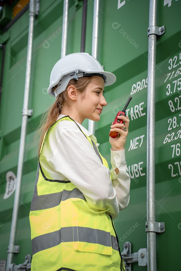 Mulher capataz sorri ao lado do contêiner de carga no armazém, gerente no capacete branco Supervisora