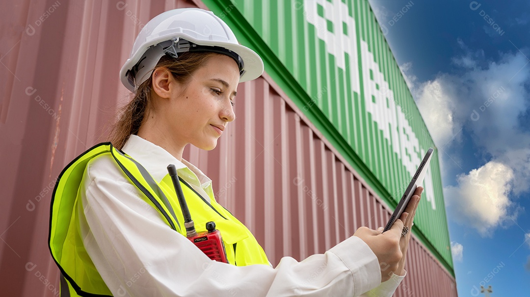 Mulher capataz sorri ao lado da empilhadeira de carga no armazém, gerente usa tablet no capacete branco Supervisor de segurança no conceito de porta do terminal personalizado de contêiner importação exportação
