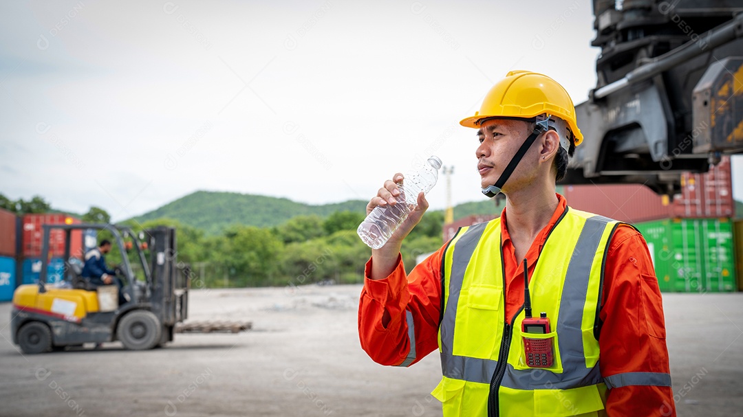 Capataz ou trabalhador está bebendo uma garrafa de água depois de terminar.