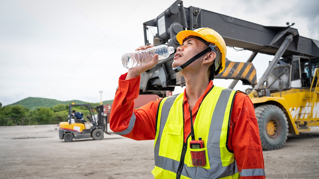 Capataz ou trabalhador está bebendo uma garrafa de água depois de terminar.