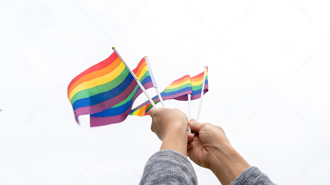 Bandeiras do arco-íris LGBTQ sendo acenadas símbolo da diversidade gay e lésbica.
