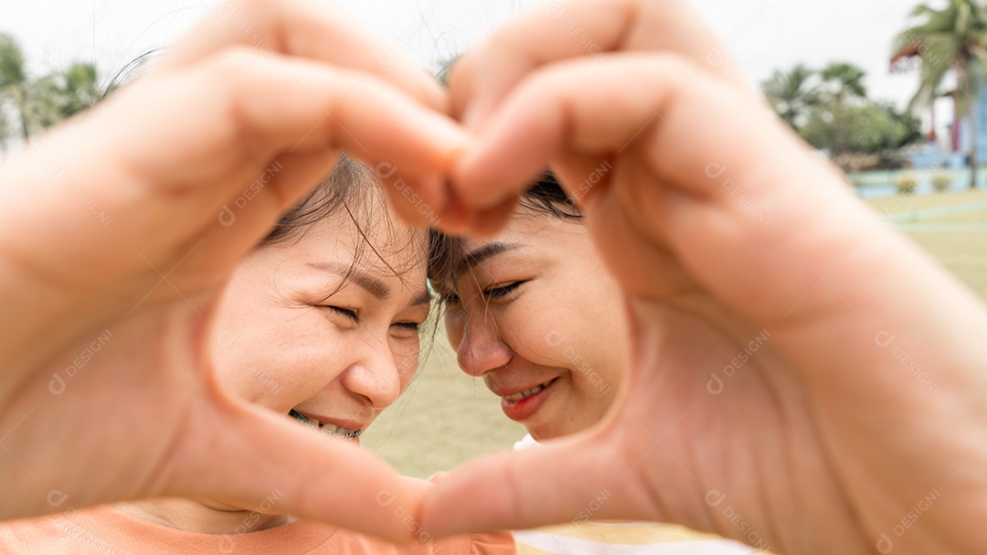 Mulher gay lésbica faz ouvir à mão o símbolo do amor ao ar livre.