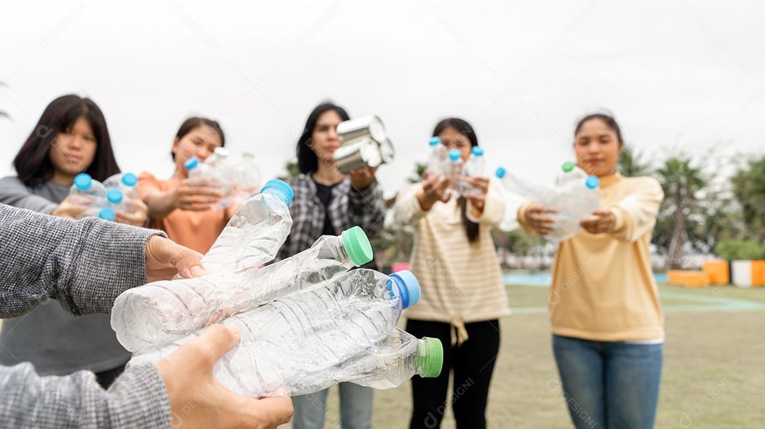 Mulher Grupo Equipe Voluntária mão segurando garrafas de plástico de lixo.