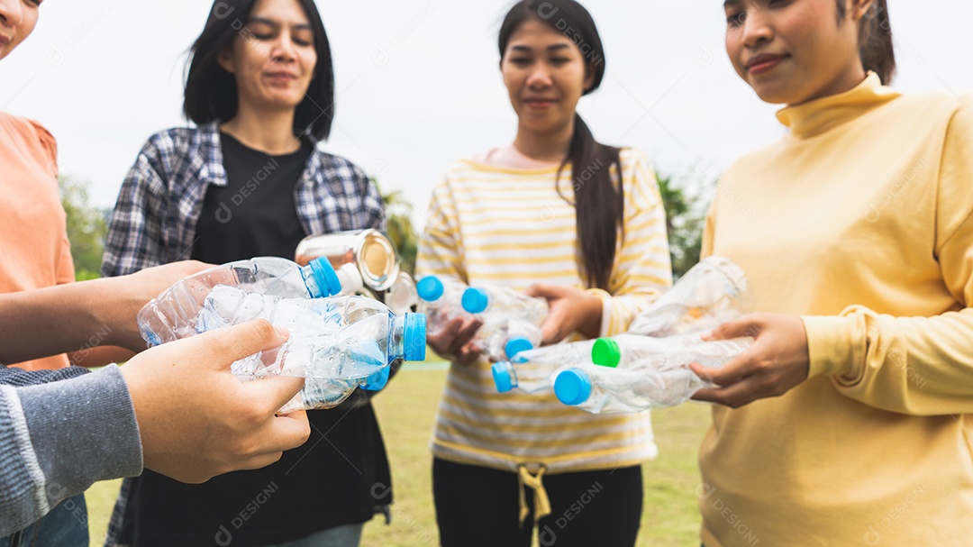 Mulher Grupo Equipe Voluntária mão segurando garrafas de plástico de lixo.
