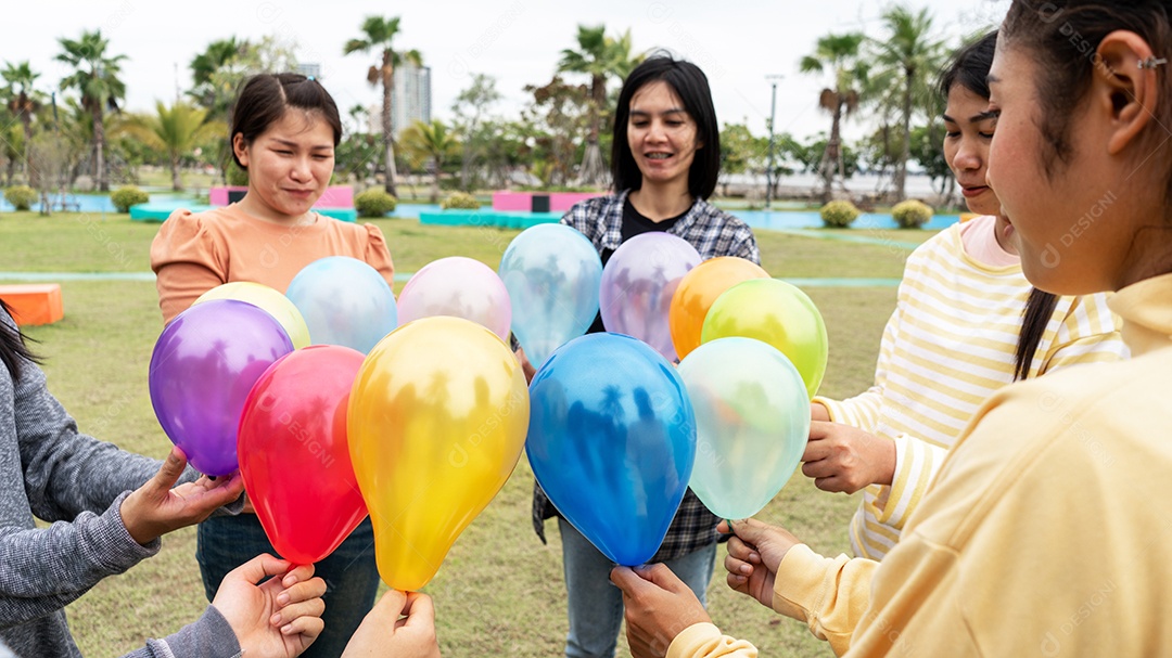 Belas mulheres se divertindo no parque soltando balões.