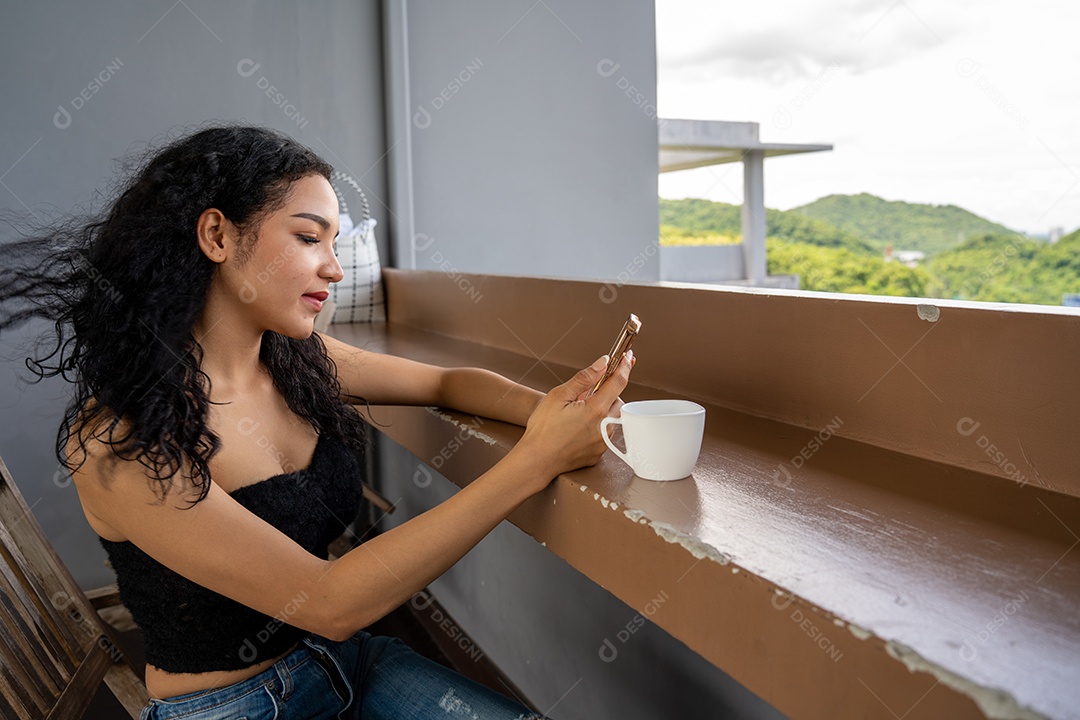 Jovem mulher bebendo uma xícara de café com um sorriso no rosto de pé e sorrindo com um sorriso confiante.