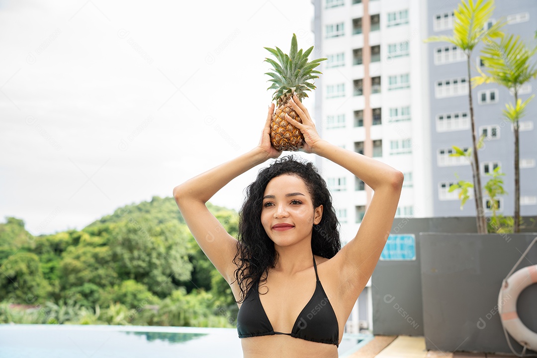 Biquíni jovem mostrando abacaxi. Sorriso de mulher de frutas de abacaxi.