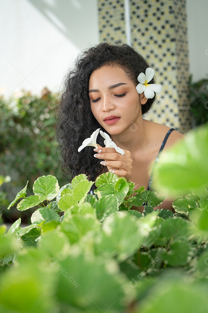 Corpo bronzeado magro de jovem em biquíni em folhas de palmeira.