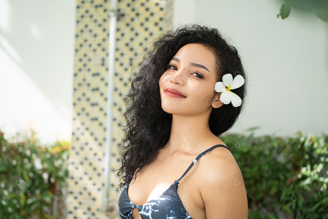 Corpo bronzeado magro de jovem em biquíni em folhas de palmeira.