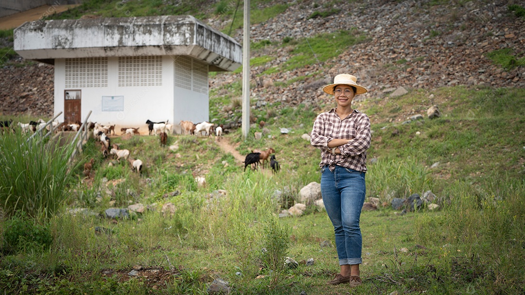 Mulher trabalhadora posando em uma fazenda de gado leiteiro de cabras ao ar livre