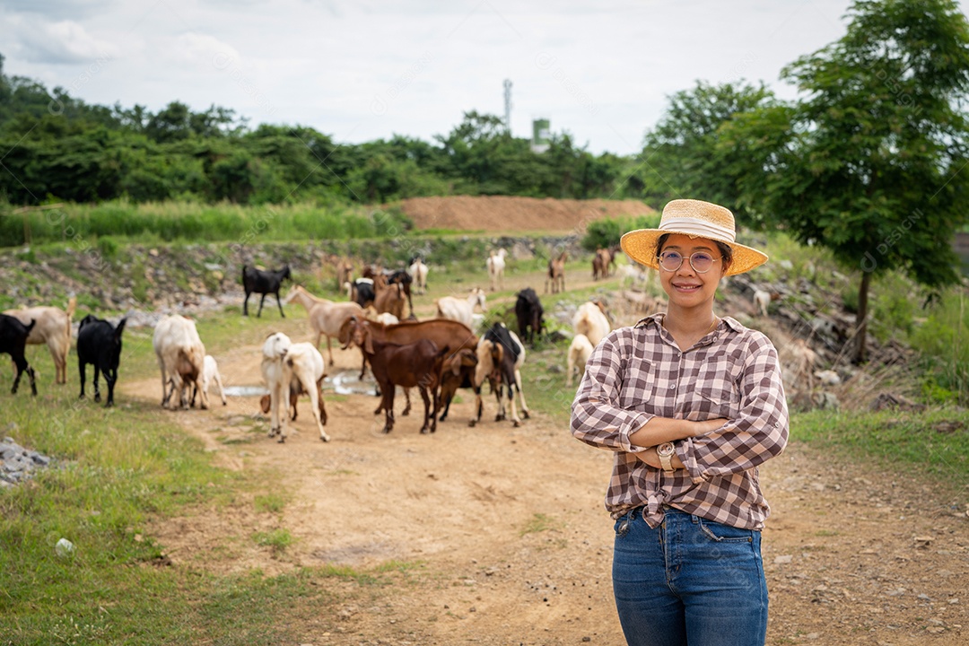 Mulher trabalhadora posando em uma fazenda de gado leiteiro de cabras ao ar livre, uma fazenda.
