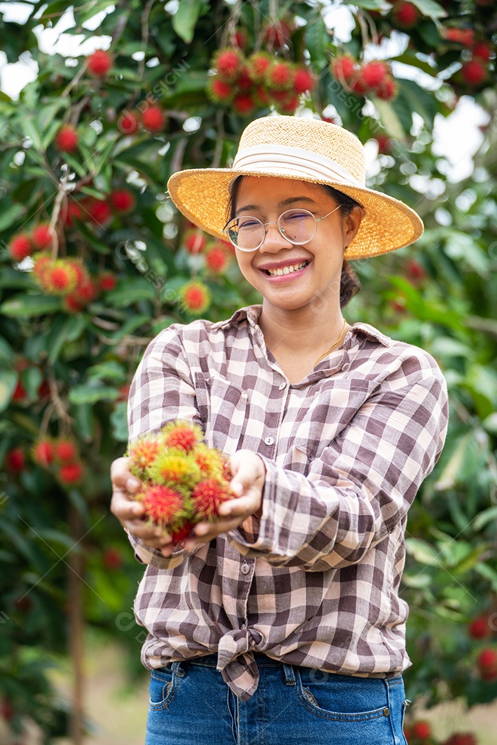 Agricultora asiática Farmer, agricultora segurando pilha de frutas.